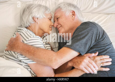 Gerne älteres paar lächelte herzlich miteinander im Bett Stockfoto