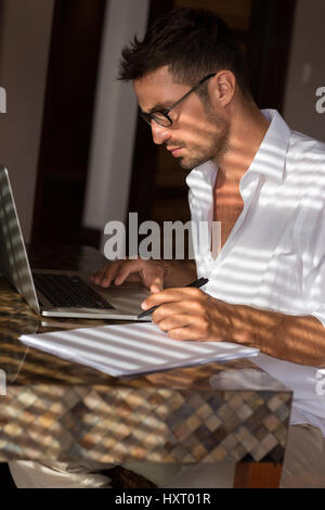 Schöne Männer arbeiten auf Laptop, Lebenslauf schreiben Stockfoto