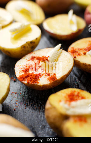 Kartoffeln mit Butter und Pfeffer rot auf schwarzem Teller Stockfoto