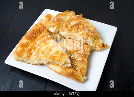 Käsekuchen mit Sesam auf einem Teller abgedeckt Stockfoto