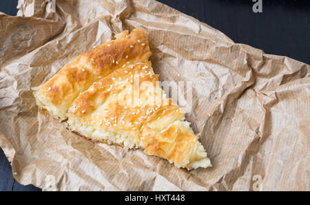 Käsekuchen mit Sesam auf Packpapier abgedeckt Stockfoto