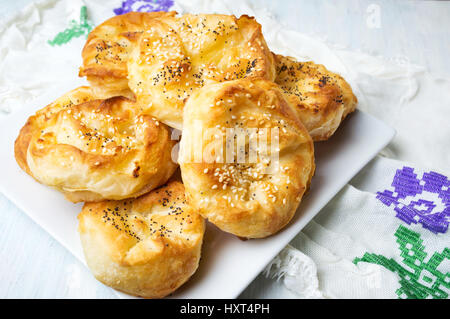 Hausgemachter Käsekuchen rollt auf einem Tisch mit Sesam Stockfoto