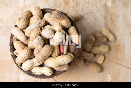 Erdnüsse mit natürlichen Muscheln in Kokosnuss Obstschale Stockfoto