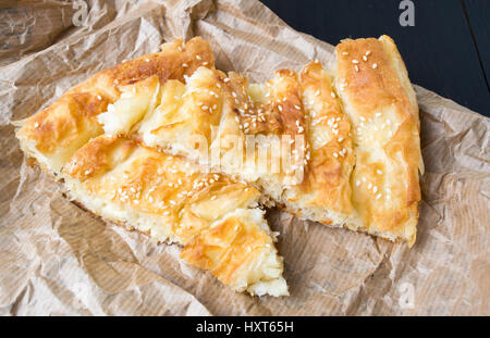 Käsekuchen mit Sesam auf Packpapier abgedeckt Stockfoto