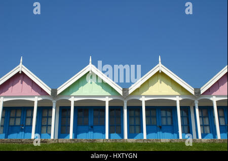 bunte Meer Strandhütten vor einem strahlend blauen Himmel Stockfoto