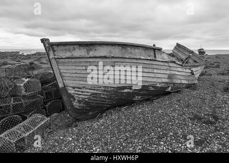 Das Wrack eines alten Fischerboots aus Holz am Schindelstrand in Dungeness, Kent, England, Großbritannien. Schwarzweiß-Version Stockfoto