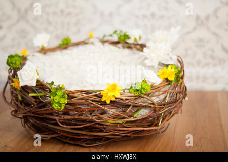 Leeren Sie den Korb mit der Decke. Osternest, mit Frühlingsblumen Girlande Stockfoto