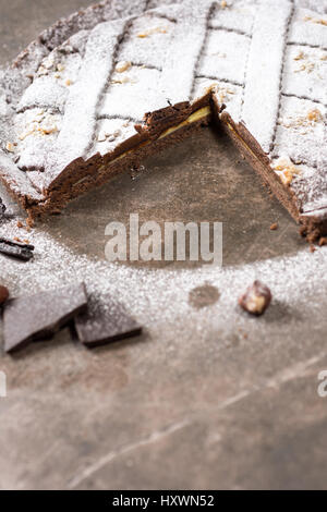 Schokoladen Torte Torte mit Haselnüssen garniert und mit Puderzucker bestreut Stockfoto