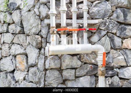 Alte Eisen-Armatur auf Grunge Steinmauer Stockfoto