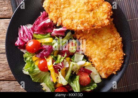 Japanisches Steak in Panko Paniermehl und Salat aus frischem Gemüse Nahaufnahme auf dem Tisch. horizontale Ansicht von oben Stockfoto