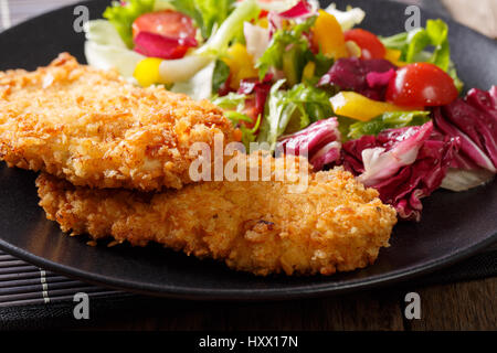 Hähnchen Schnitzel in Paniermehl Panko und frischem Salat mischen Makro auf dem Teller. horizontale Stockfoto