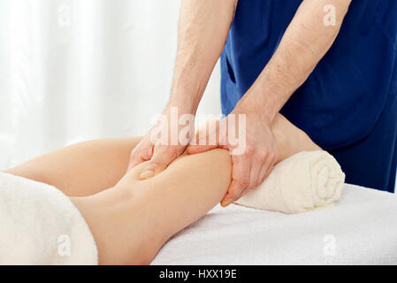 Männliche Hände, die Beine tun massage für Frau Nahaufnahme Stockfoto
