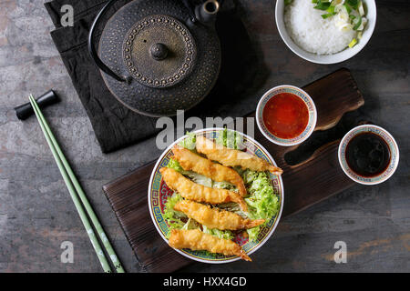 Fried Tempura Garnelen auf Blattsalat mit Saucen. Serviert im traditionellen Porzellanplatte mit Stäbchen auf Holz Brett servieren. Teekanne, Schüssel mit Reis. Ove Stockfoto