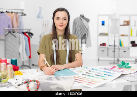 junge Mode-Designer am Schreibtisch in ihrem Atelier Stockfoto
