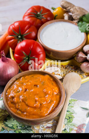 Schüssel mit pflanzlichen Tikka Masala Sauce und Zutaten, die eingehen, so dass es - rote Tomaten, Paprika, Karotten, Koriander Blätter, Zwiebel, Knoblauch, Juwel Stockfoto