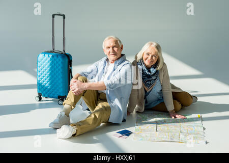 Senior Mann und Frau sitzen auf Boden mit Reisen, Karte, Pässe und Tickets, Reisen Konzept Stockfoto