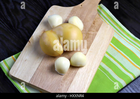 Italienische Scamorza Käse Ebene gesponnen und geräuchert - Süditalien typische Birne erinnernde Form Quark auf Holzbrett auf dunklen Holztisch liegend Stockfoto