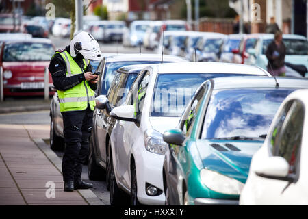 Parkplatz Durchsetzung Büros in Motorrad Getriebe prüfen Parken an der Straße in Hulme, Manchester, England, UK. Stockfoto