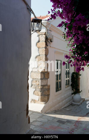 Straßenecke mit alten weiß gewaschen, Haus, rosa Bougainvillea Pflanze, Straßenlaterne und grünen Fensterläden im Dorf Lindos, Rhodos, Griechenland Stockfoto