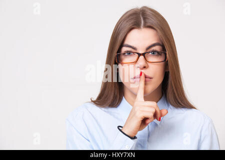 Halten Sie Ihre Geheimnisse! Studio-Porträt der junge schöne Geschäftsfrau gestikulieren "shh" an der Kamera. Stockfoto