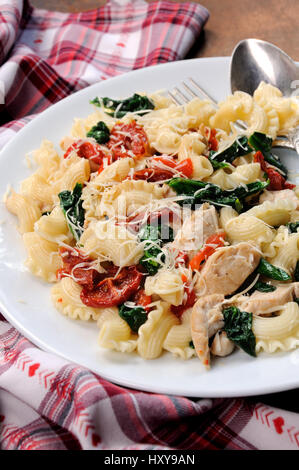 Warmer Salat Nudeln mit Huhn, Sonne getrocknet, Tomaten, Spinat, Paprika und aromatisierte Parmesan-Käse Stockfoto