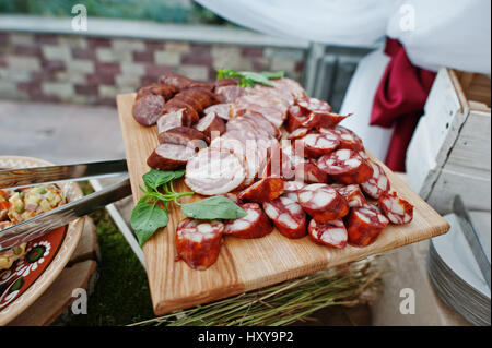 Verschiedene Würste auf Holzbrett bei Hochzeit catering. Stockfoto