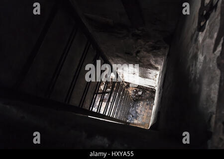 Alten leeren verlassenen Bunker Interieur mit verrosteten Metallleiter hinunter vom dunklen Raum Stockfoto