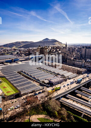 Glasplatzdächer der Edinburgh Waverley Station mit Waverley-Brücke im Vordergrund und Salisbury Crags und Arthur's Seat in der Ferne. Stockfoto