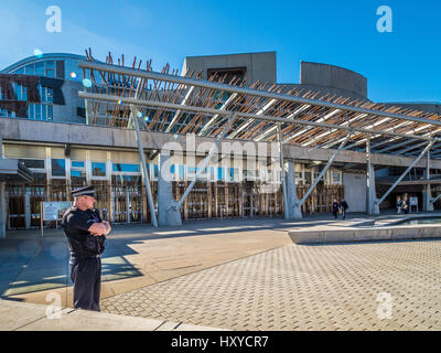 Ein einziger Polizist bewacht an einem heißen, sonnigen Tag die Front des schottischen Parlamentsgebäudes. Holyrood, Edinburgh, Schottland. Stockfoto