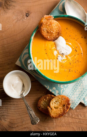 Kürbis-Suppe in eine Schüssel mit Kokos-Creme und gebratenem Brot-Croutons mit Sesam Stockfoto