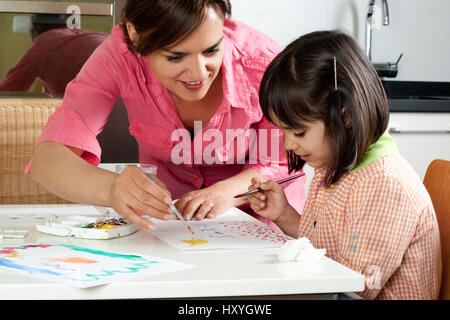 Mutter und Tochter zusammen zu Hause mit Pinsel und Wasserfarben malen Stockfoto