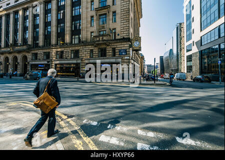 Geschäftsmann, überqueren einer Straße im Stadtzentrum von Glasgow an einem sonnigen Sommertag Stockfoto