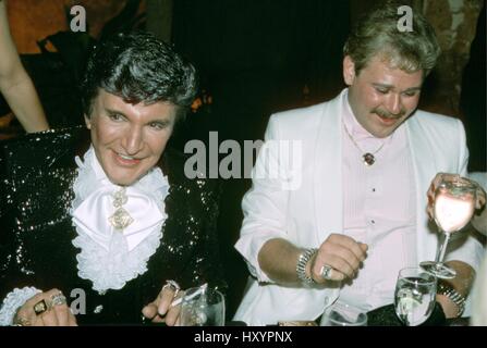 Liberace und Freund CareyJames Teilnahme an der after-Party statt im Trump Tower feiert seine Premiere-Leistung in der Radio City Music Hall.  April 1985.  © RTMcbride / MediaPunch Stockfoto