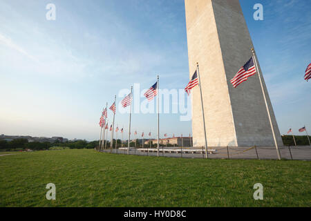 Weitwinkel-Blick auf das Washington Monument mit amerikanischen Fahnen an der Basis Stockfoto