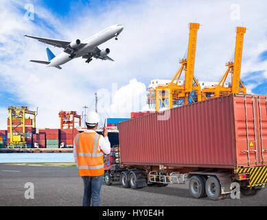 Arbeitnehmer spricht am Walkie-talkie für controlling Verladung Container in einem industriellen Hafen mit LKW Container und Cago Transportflugzeug flyin-Dock Stockfoto