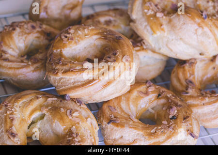 Auswahl an frisch gebackenen leckeren Windbeutel mit gerösteten Mandeln bedeckt. Beliebtes Französisches Dessert. Stockfoto