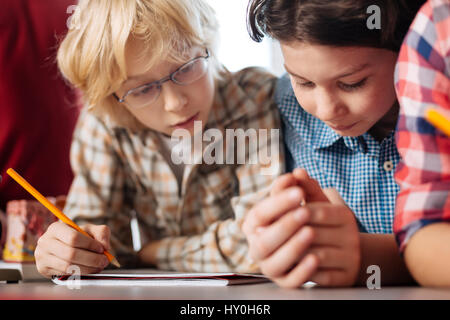 Aufmerksame neugierige Kinder lesen die Zuordnung Stockfoto