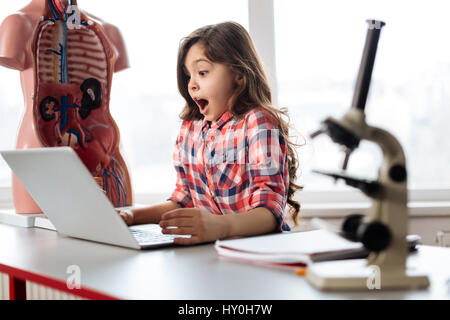 Emotionale aufgewecktes Mädchen erstaunt über ihre Ergebnisse Stockfoto