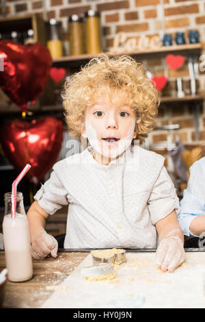 Porträt von verlassen kleiner Junge mit Mehl-Streifen Gesicht machen cookies Stockfoto