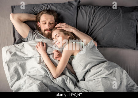 Draufsicht des jungen Paares schlafend im Bett Stockfoto