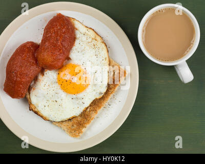 Spiegelei und Tomatenkonserven auf Toast vor einem grünen Hintergrund Stockfoto