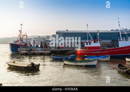 Teignmouth Trawler, andocken, um den Fang von Fischen auf dem Fisch-Kai in Teignmouth, Devon, UK zu entladen. Zwei junge Männer sind auch auf einem Ponton Angeln. Stockfoto