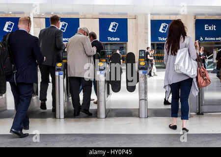 Zugreisende gehen durch automatische Schranken am Bahnhof Waterloo in London. Metapher, Austritt - Engländer EU verlassen Stockfoto