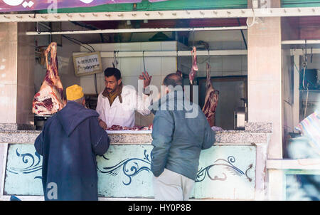 Traditionelle Metzgerei in Marrakesch Straße mit hängendes Fleisch, Rindfleisch, Lamm mit Verkäufer und Kunden Stockfoto