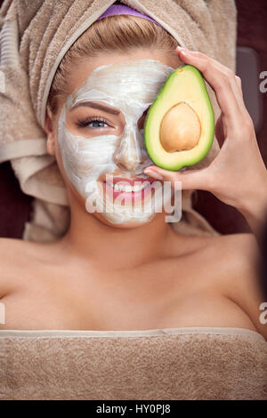 Schönes Spa-Frau in Gesichtsmaske und avocado Stockfoto