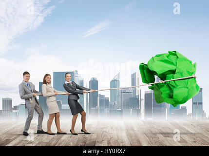 Junge Geschäftsleute im Freien und riesige Papier Kugel als Symbol der Kreativität Stockfoto