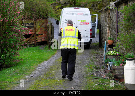 Rückansicht eines Jodler-Lieferers und eines weißen Transporters Lieferung eines Pakets auf einem ländlichen Grundstück in Carmarthenshire West Wales Großbritannien KATHY DEWITT Stockfoto