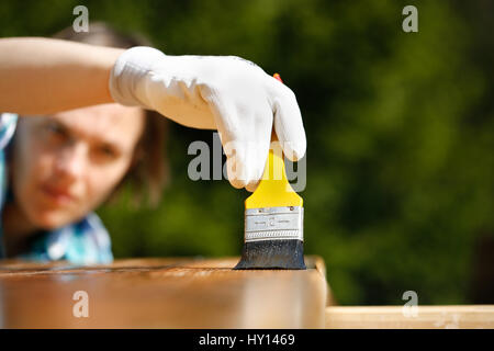 Frau Zimmermann Inspektion ihrer Arbeit nach Behandlung von Holz mit Schutz Farbe. Outdoor-Schutz, Zimmerei, hart an der Arbeit, Qualitätskontrolle, home impr Stockfoto