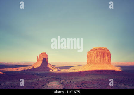 Retro stilisierte Bild des Monument Valley bei Sonnenuntergang, eines der Top-Attraktionen in den USA. Stockfoto