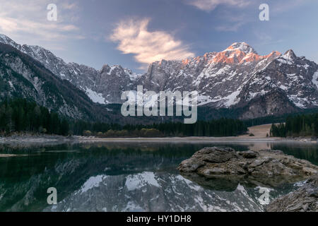 Sonnenaufgang über dem Mt. Mangart und Fusine Seen Stockfoto